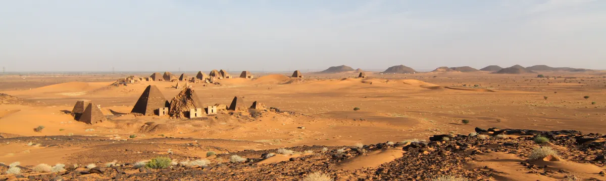 סודן: Explore the ancient pyramids of Meroë against the vast desert landscape in Sudan.