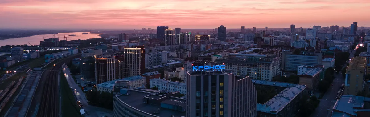 Stunning aerial view of Novosibirsk city skyline under a vibrant sunset sky.