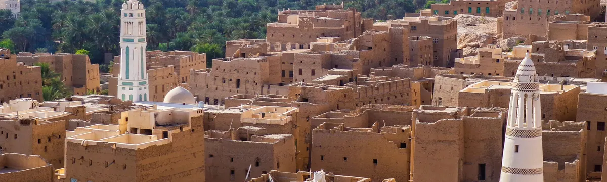 תימן: Aerial view showcasing the traditional architecture of a historic town in Yemen with iconic towers and desert landscape.