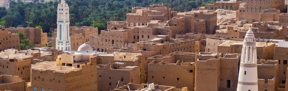 תימן: Aerial view showcasing the traditional architecture of a historic town in Yemen with iconic towers and desert landscape.