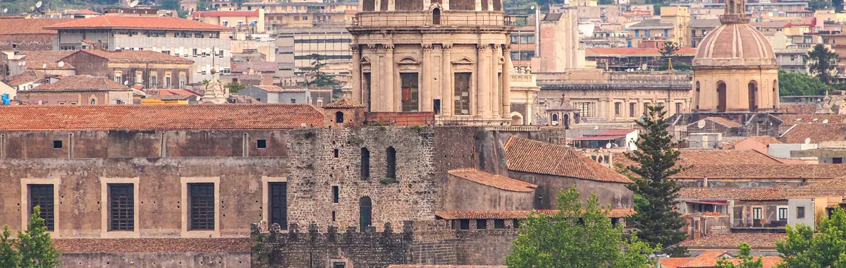 Panoramic view of Catania's historic architecture featuring domes and cityscape.