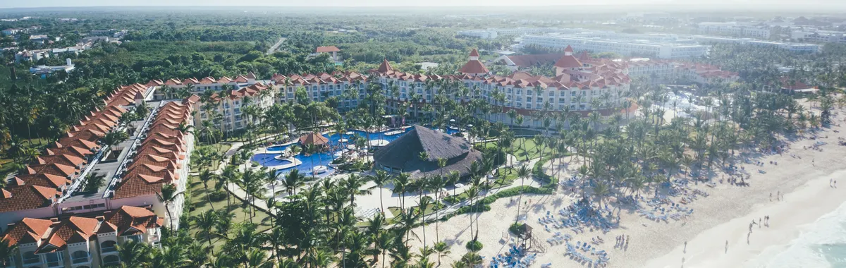 Aerial shot of a tropical beach resort in Punta Cana with palm trees and ocean views.