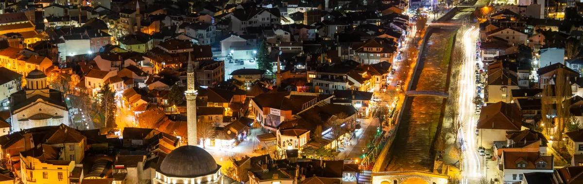 Captivating aerial view of Prizren at night showcasing illuminated streets and architecture.