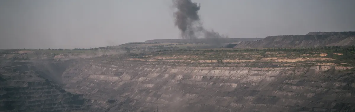 Aerial shot of the smoky quarry in Novokuznetsk, Russia, showing industrial mining activity.