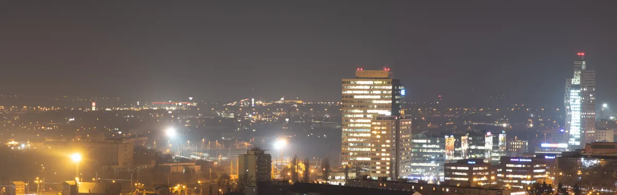 Skyline of Brno city at night with modern architecture and glowing city lights.
