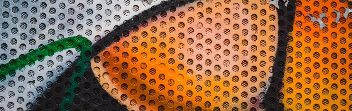 Close-up of colorful graffiti art on a perforated metal surface in Ostrava, Czechia.
