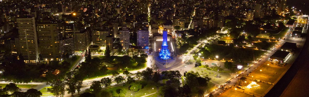 Stunning aerial night view of National Flag Memorial in Rosario, Argentina, glowing in vibrant lights.