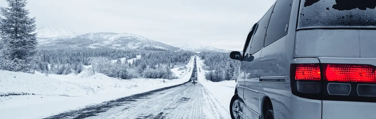 A van on a snowy road in Magadan, capturing the vast winter landscape of Russia.