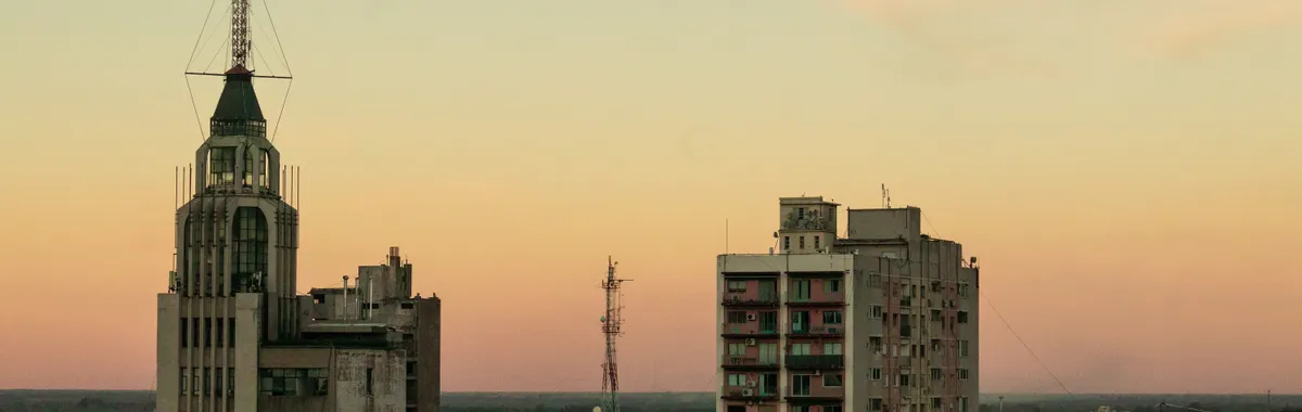 View of Mendoza city skyline at sunset, featuring prominent buildings and towers.