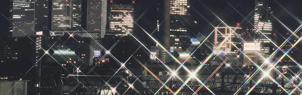 Dazzling view of Nagoya's skyline at night, showcasing illuminated skyscrapers and railway tracks.