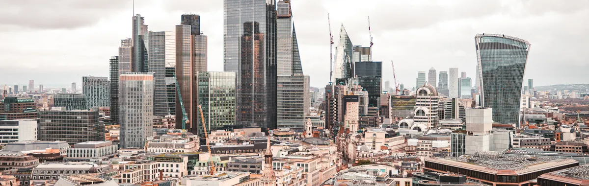 A stunning aerial view of London's modern skyscrapers under overcast skies, showcasing its architectural marvels.
