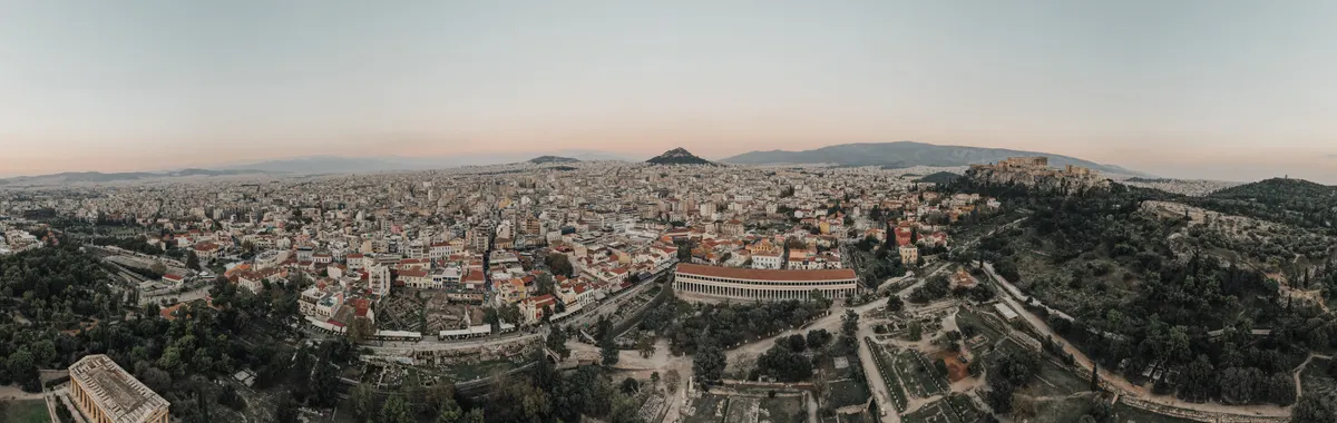 A stunning aerial view of Athens cityscape at sunrise, showcasing historical landmarks.