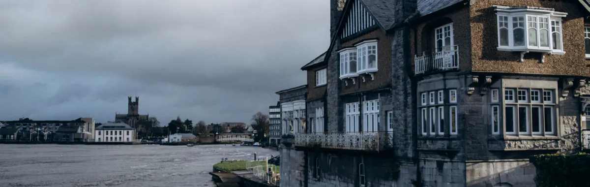 Traditional architectural houses lining the Shannon River in Limerick, Ireland.