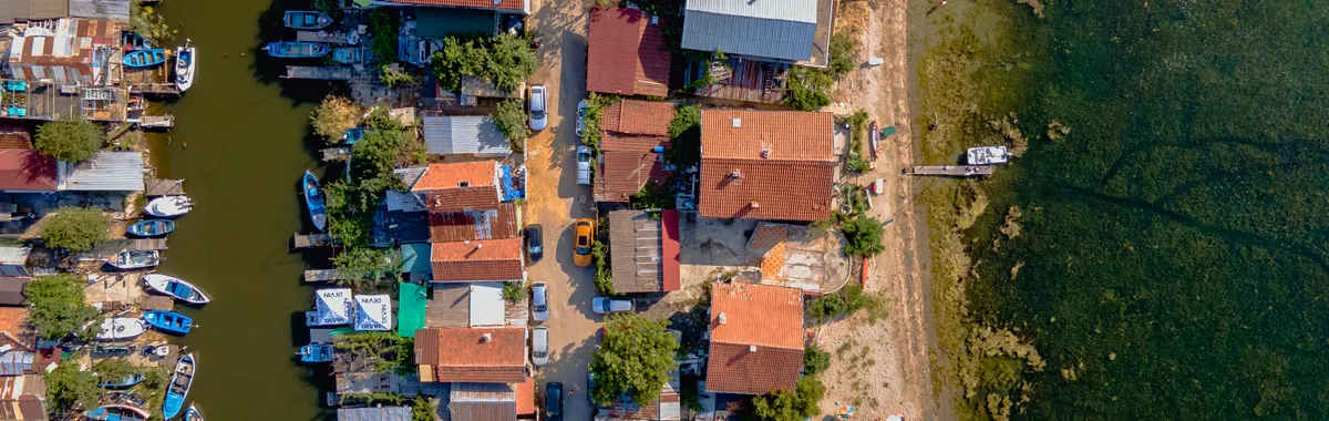 A drone captures a colorful coastal village in Burgas, Bulgaria alongside serene waters.