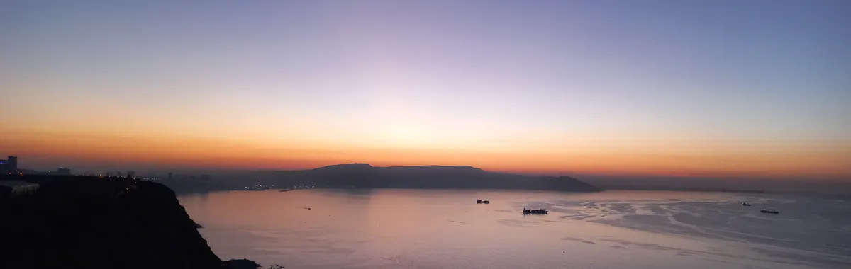 Captivating sunset over the Oran coast with silhouettes of ships and a dramatic horizon.