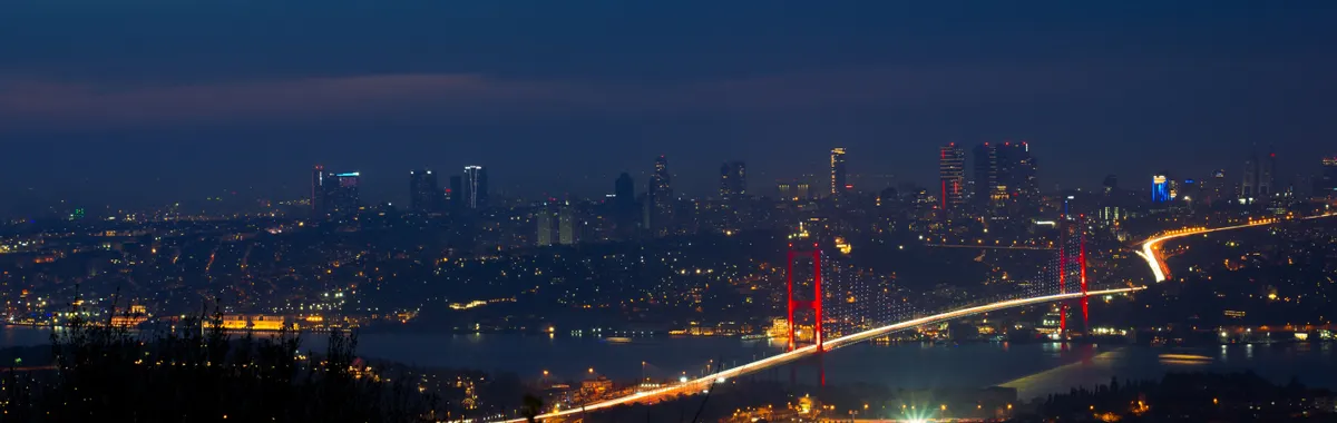 Illuminated Bosphorus Bridge and Istanbul cityscape captured at night creating a breathtaking urban scene.