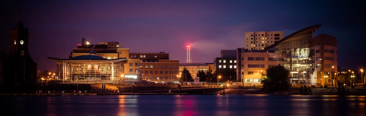 Stunning view of Cardiff Bay's illuminated skyline at night reflecting on the water.