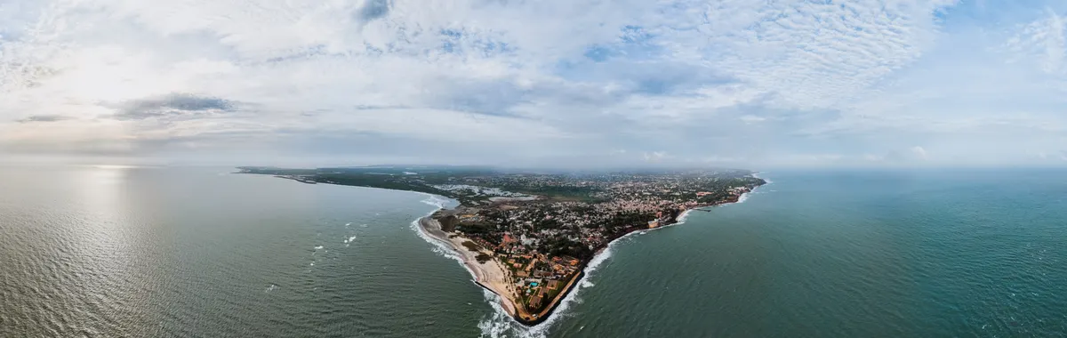 גמביה: Stunning aerial view of Banjul, The Gambia's scenic coastline under a cloudy sky.