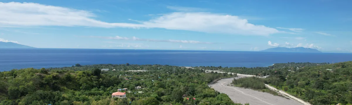 טימור-לסטה: A scenic aerial view capturing the lush countryside and serene ocean of Liquica, Timor-Leste.