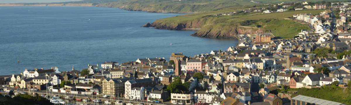האי מאן: A picturesque view of Peel marina and town on the Isle of Man, showcasing the coastline.