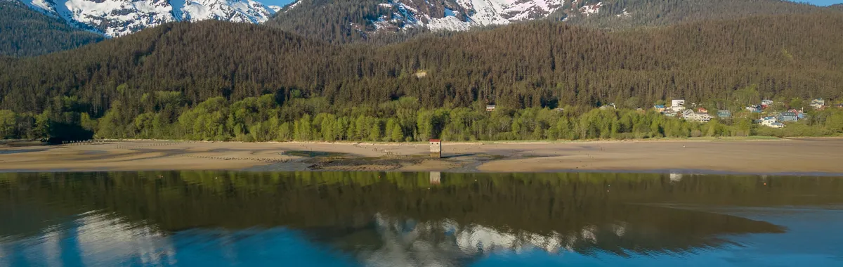 Breathtaking view of snow-capped mountains and serene lake reflections in Juneau, Alaska.
