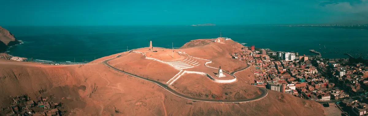 A stunning aerial view of Callao, Peru featuring coastal landscapes, hills, and ocean horizon.