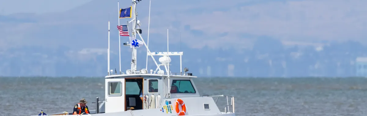 San Rafael Police boat patrolling along a scenic coastline under clear skies.