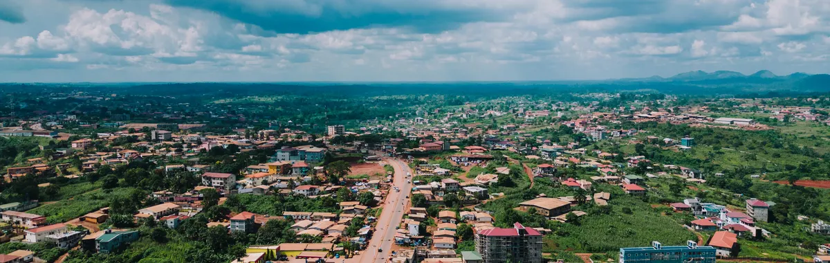 Aerial cityscape of Yaoundé, Cameroon showcasing urban development under a vibrant sky.
