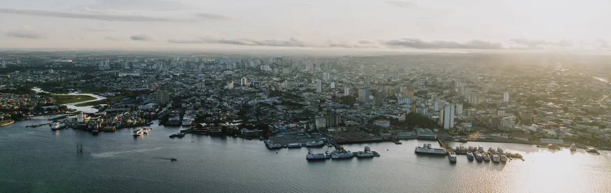 A breathtaking aerial view of Manaus' cityscape and waterfront at sunset.