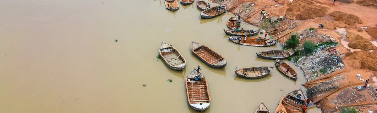 ניז׳ר: Aerial view of wooden boats along the Niger River in Bamako, Mali. Busy riverbank activity.