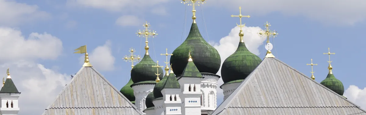 Stunning view of Astrakhan Kremlin's green domes under a bright blue sky.