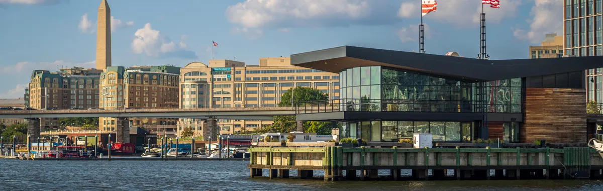 Scenic waterfront view of Washington DC featuring the Washington Monument and modern architecture.