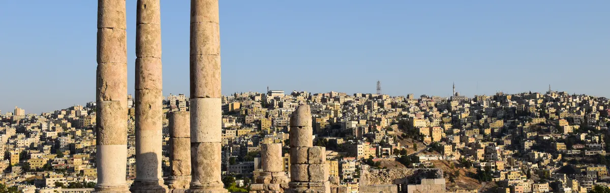 Majestic view of the Temple of Hercules ruins against Amman's sprawling cityscape.