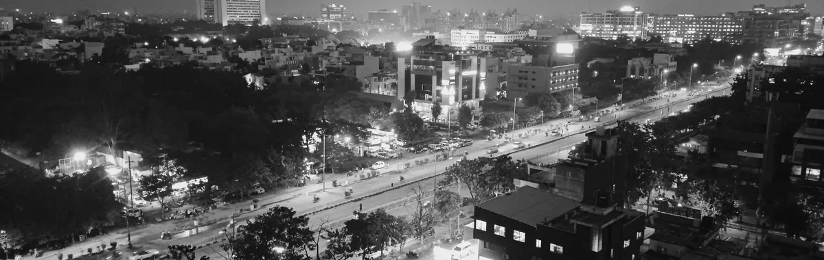 Black and white aerial view of Indore cityscape at night, showcasing urban streets and buildings.