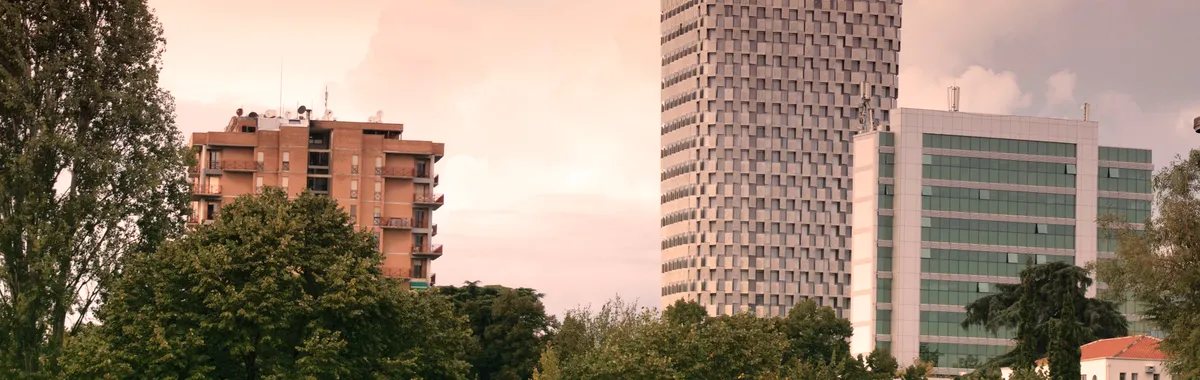 View of modern skyscrapers and lush greenery in Tirana, Albania during daylight.