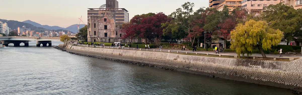 Scenic view of Hiroshima Peace Memorial Park with autumn foliage along the river.