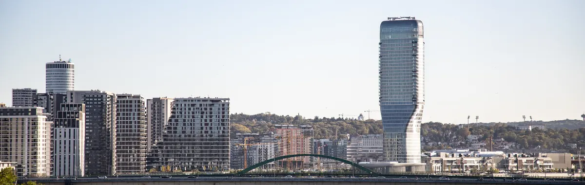 A stunning view of Belgrade's skyline with the Belgrade Tower by the river under a clear sky.