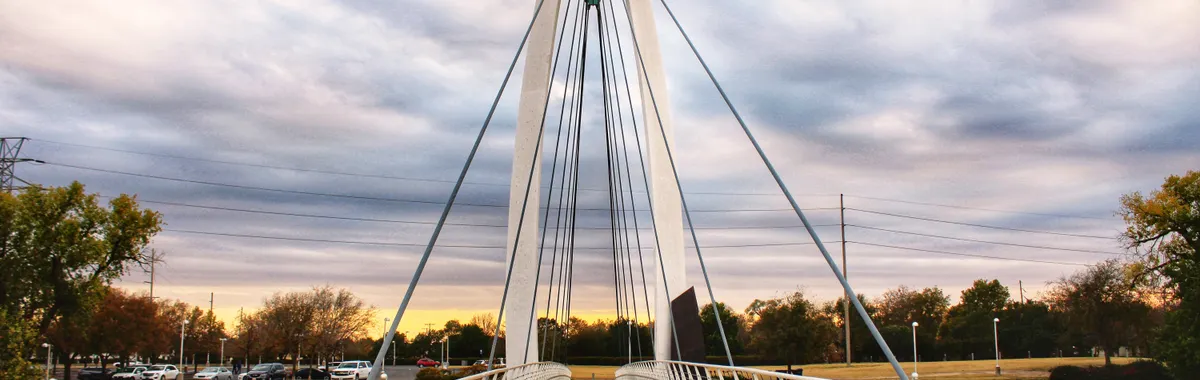 A stunning view of a suspension bridge in Wichita, KS, during sunset, showcasing architectural beauty.