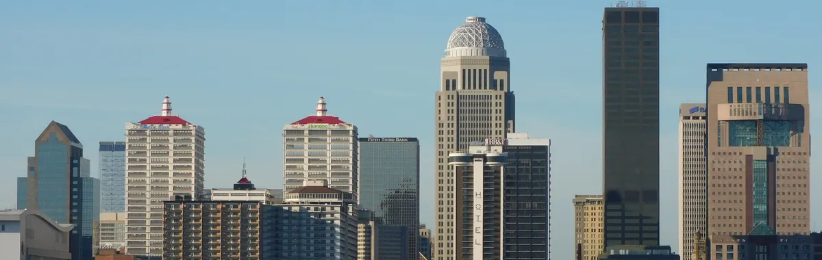 Stunning view of Louisville's skyline with modern skyscrapers reflecting on river.