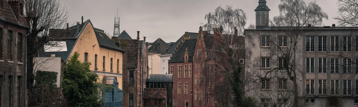 בלגיה: Atmospheric view of a historic canal and old town architecture in Ghent, Belgium.