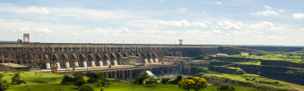 פרגוואי: Experience the majestic Itaipu Dam surrounded by lush greenery in this scenic landscape view.