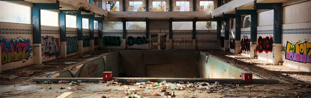 Explore this eerie, abandoned indoor pool in Foggia, Italy, filled with graffiti and debris.