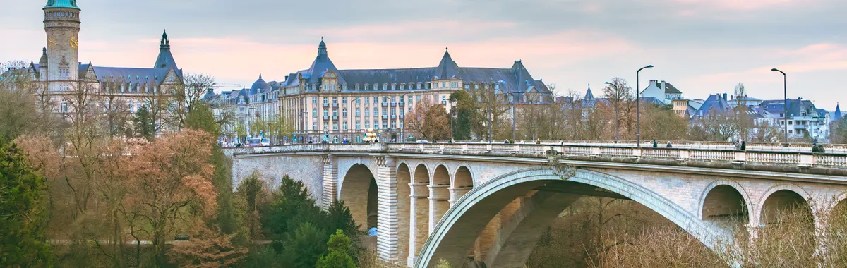 Scenic view of the iconic Adolphe Bridge amidst fall foliage in Luxembourg City.