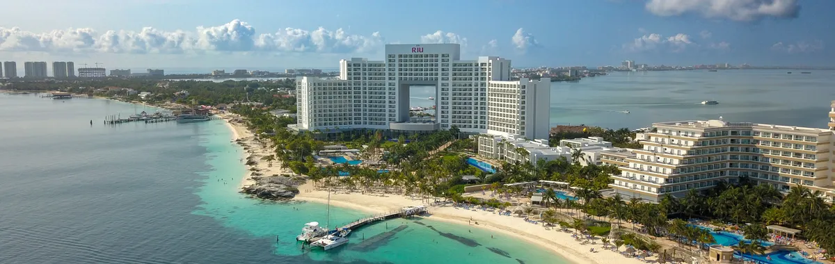 A stunning aerial view of a hotel on the Cancún beachfront, showcasing the coastline and sea.