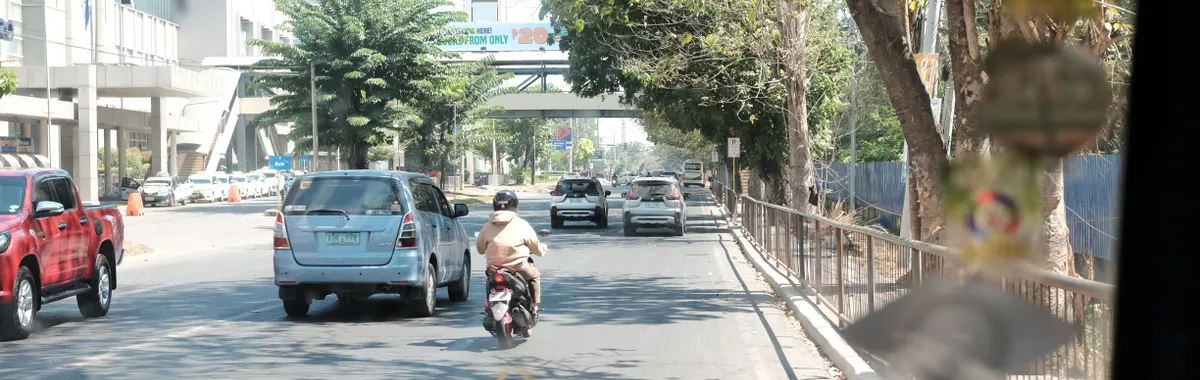 View of vehicles including a motor scooter on a bustling street in Cagayan de Oro, Philippines.