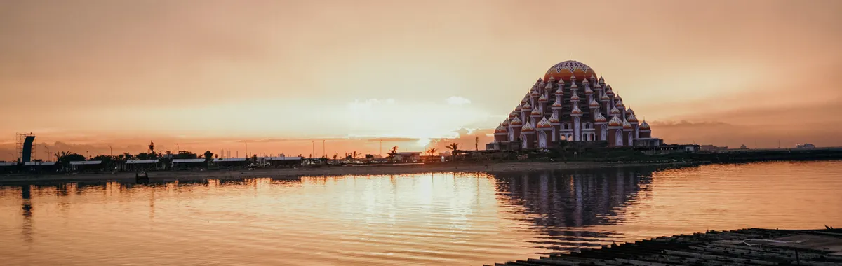 Capture of Makassar's Floating Mosque at sunset reflecting over calm waters.