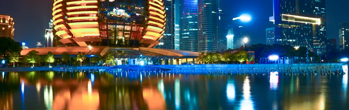 Stunning reflection of Hangzhou's illuminated skyline featuring modern architecture during the night.