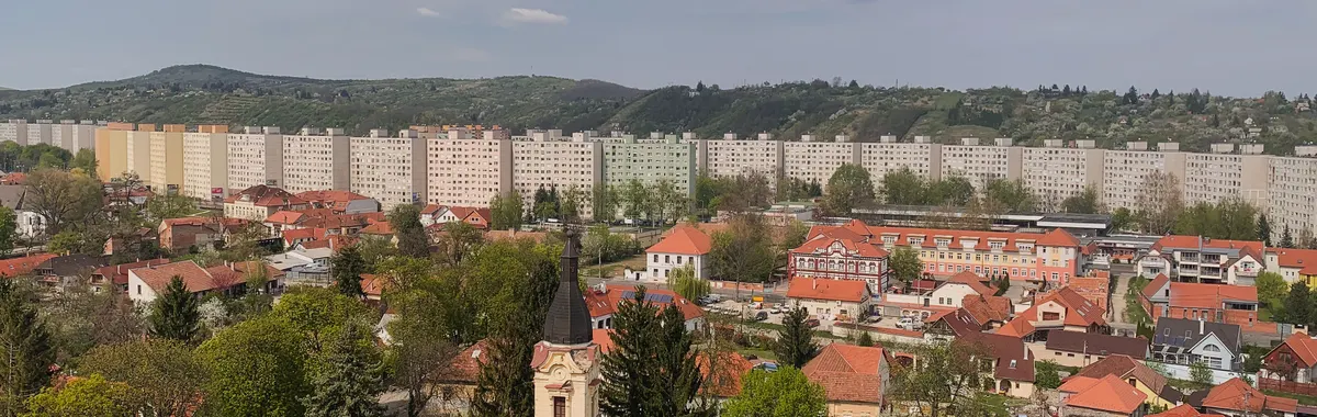 Aerial view of Miskolc, Hungary showcasing apartment buildings, lush greenery, and urban landscape.