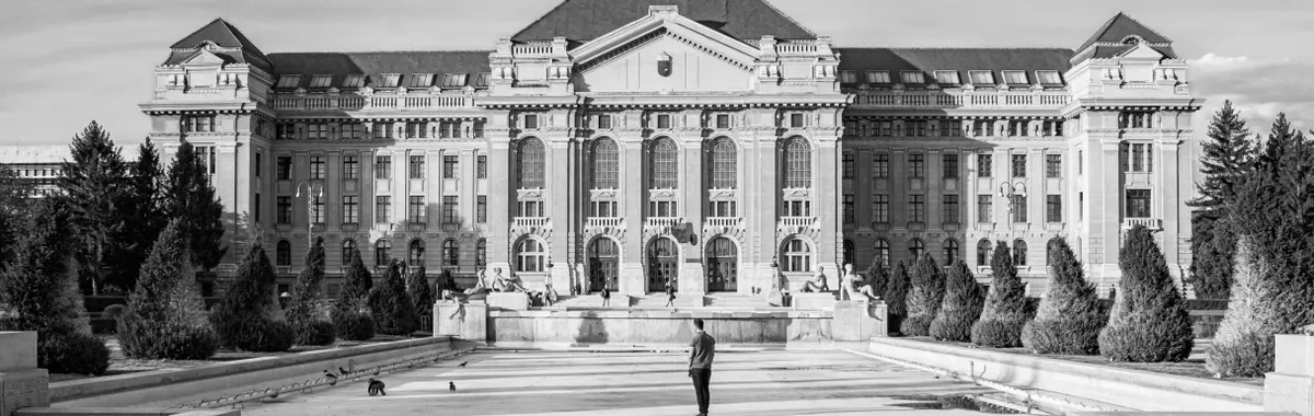 Historic University of Debrecen building with classic facade in black and white.