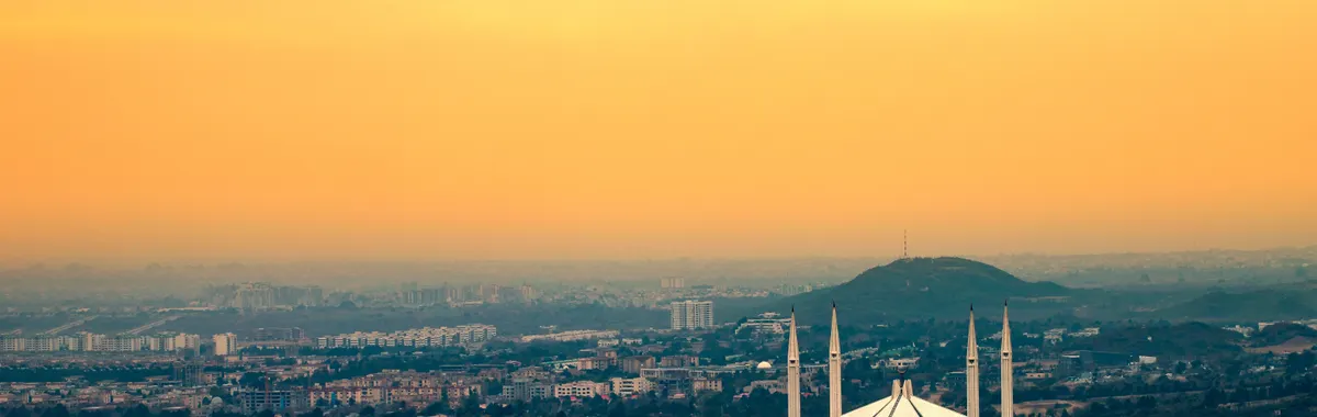 Captured from above, Islamabad's Faisal Mosque silhouetted against a vibrant sunset sky.